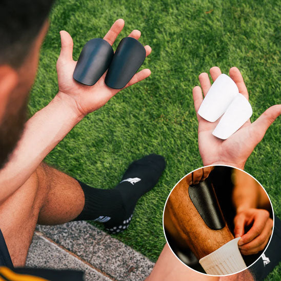 homme tient protege tibia dans mains droite main gauche