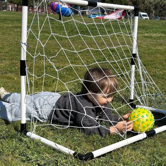 Enfant joue avec ballon de football devant cage de foot | Goalino-Foot-Kids- Foot Expert